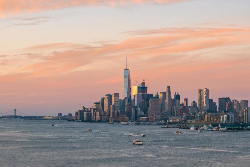 有晚霞的天空下日落时分的曼哈顿城市建筑天际线