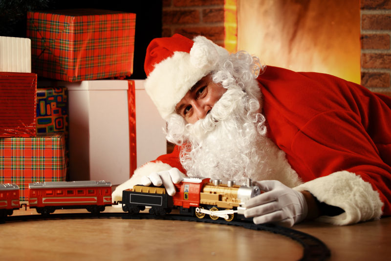 趴着玩玩具火车的圣诞老人