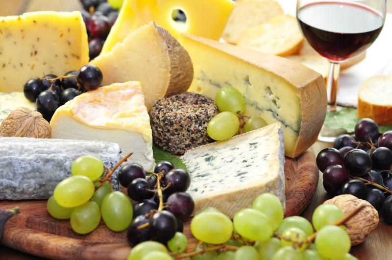 木板上的奶酪和葡萄等美食