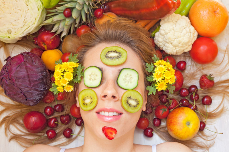 女性脸上放满了很多水果和蔬菜