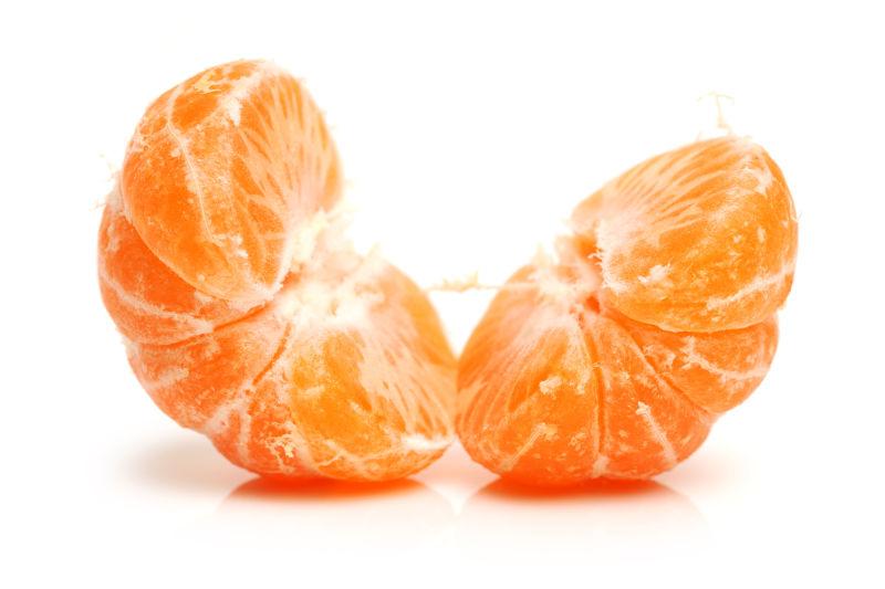 白色背景中拨开皮的橘子