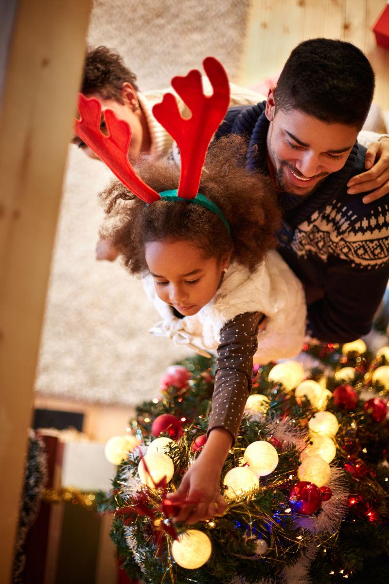 父亲抱着孩子家庭装饰圣诞树