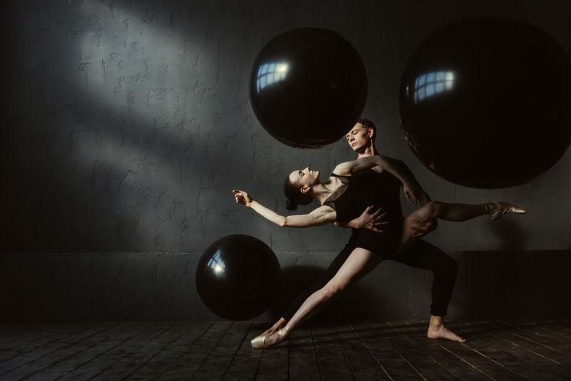 黑暗的灯光下两个配合的芭蕾舞舞者