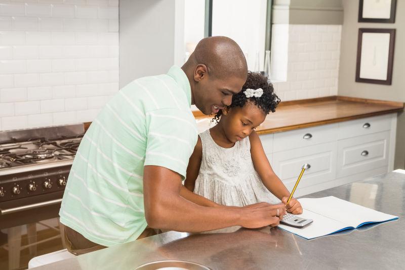 父亲在厨房帮助女儿做作业