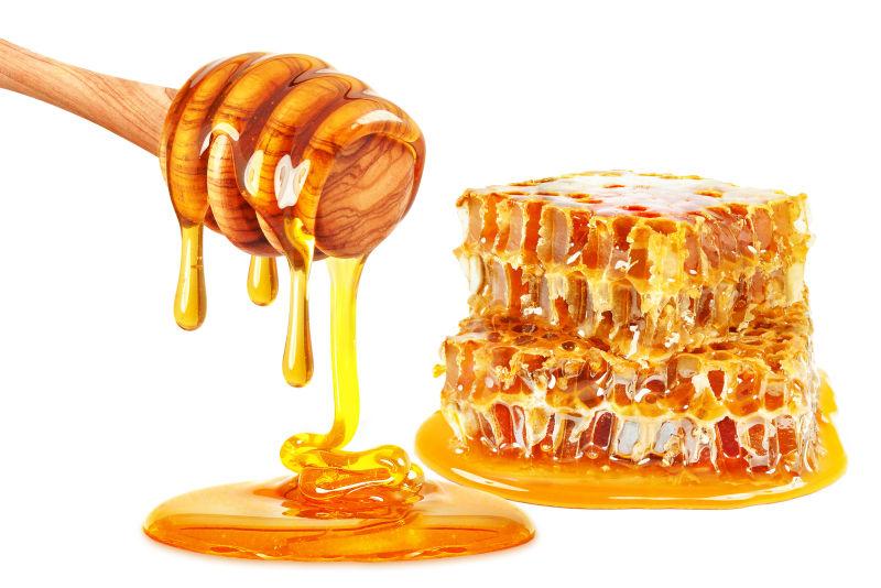 白色背景下的金黄色的蜂蜜和蜂巢