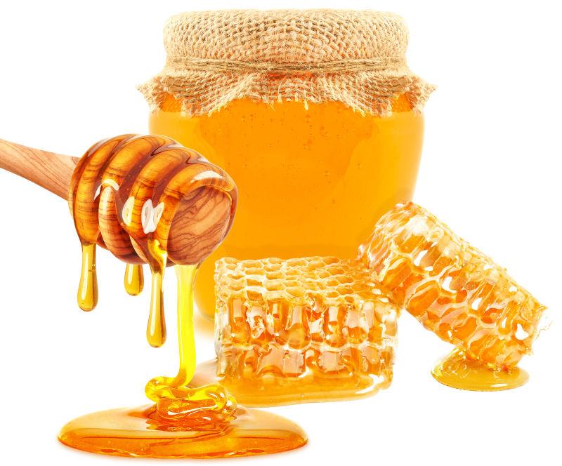 白色背景下从蜂巢中提取金黄色的蜂蜜
