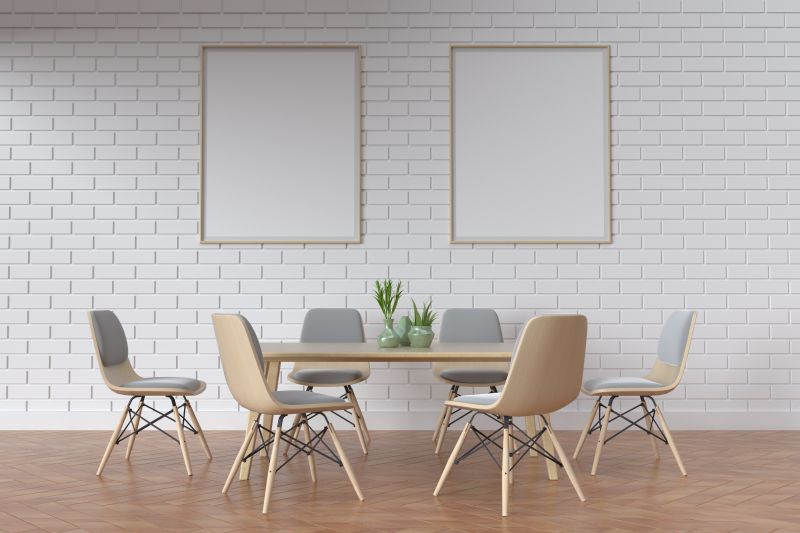 室内摆放整齐的桌椅和挂在墙上的空白白色画框