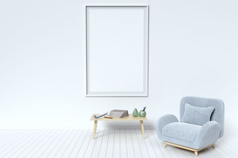 室内挂在墙上的空白白色画框和放在地上沙发