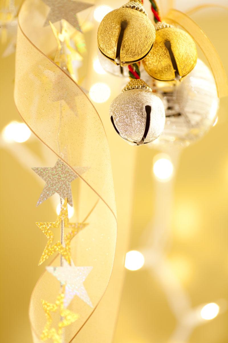金色灯光背景下的金色缎带和铃铛装饰