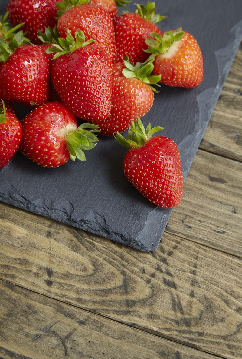 一堆新鲜成熟的草莓在木桌上