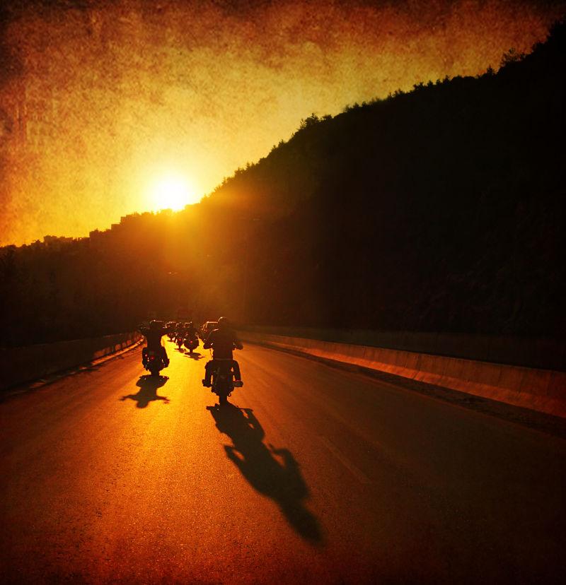 日落时分街道上骑摩托车的人