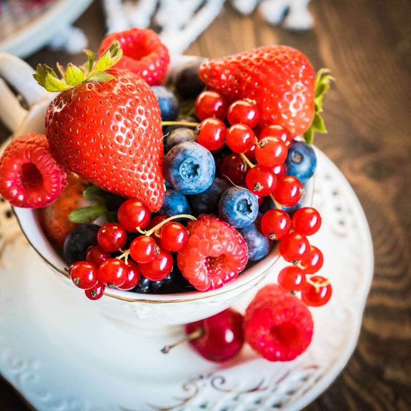 放在茶杯中的蓝莓草莓等水果 