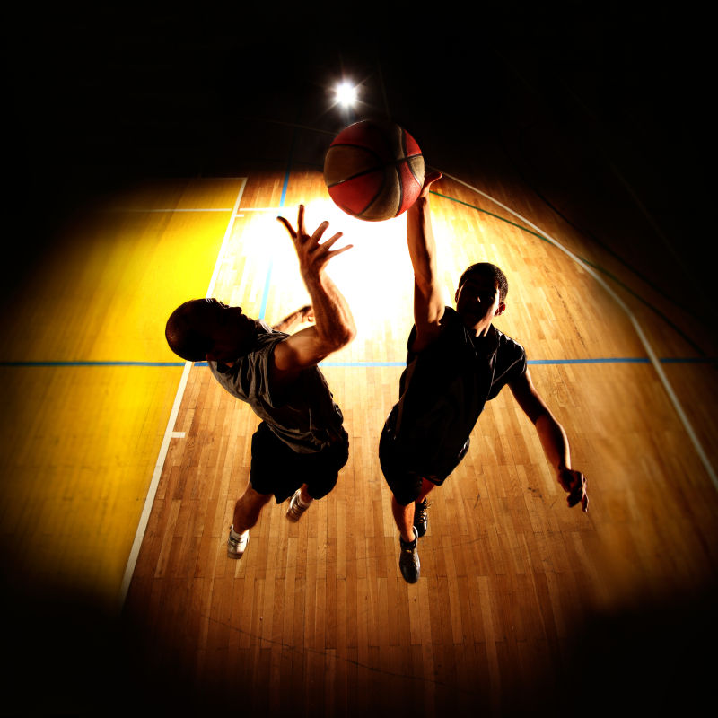 两位篮球运动员跳起来在抢球