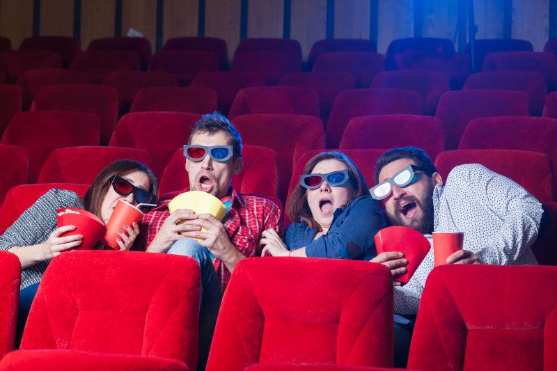 朋友们在电影院里戴着3D眼镜看电影