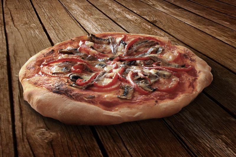 木制背景下美味的披萨