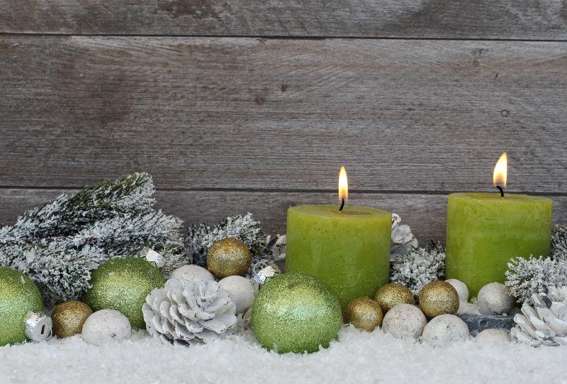 圣诞球与燃烧的绿色圣诞蜡烛