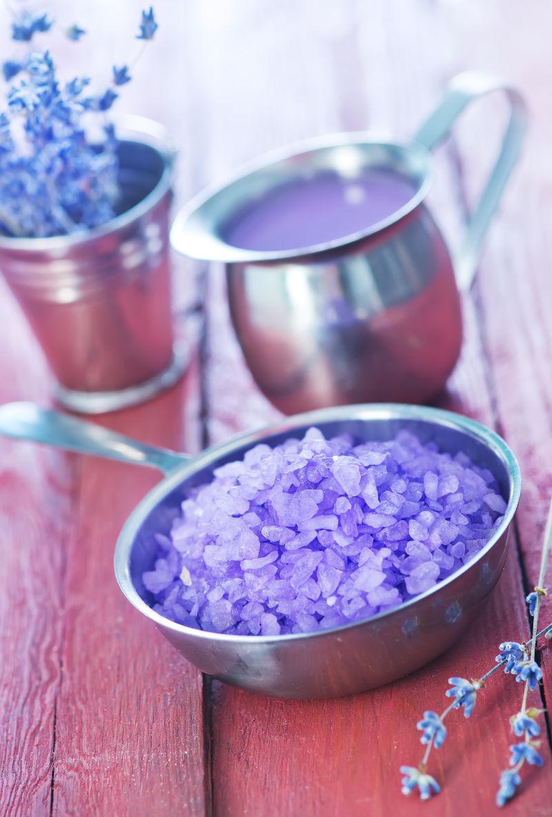 金属碗和桌子上的紫罗兰盐