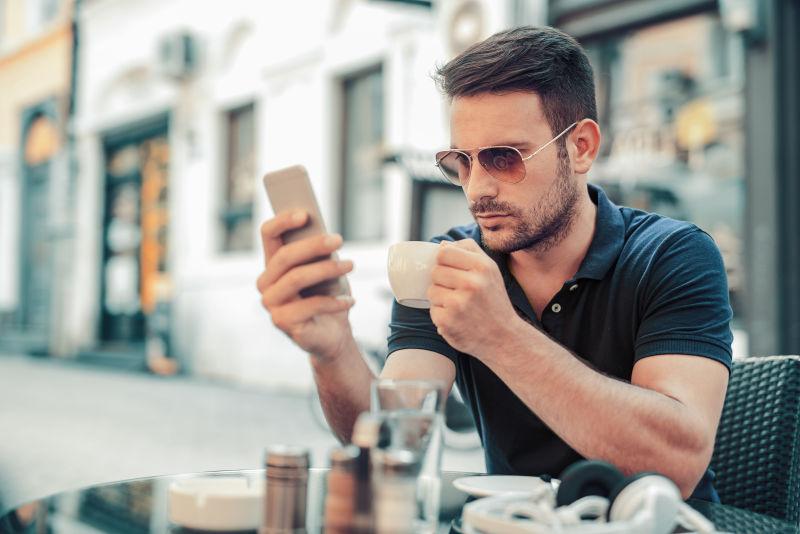 在喝咖啡玩手机的男人