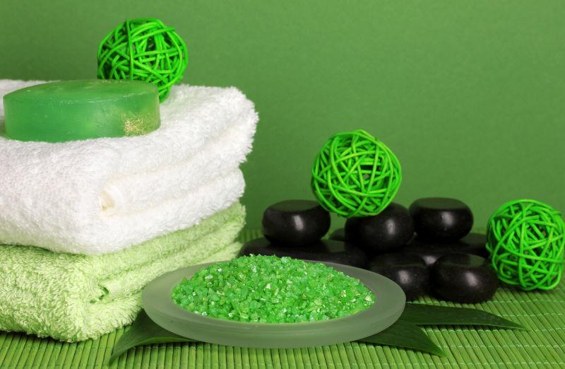 绿色背景下的SPA石毛巾海盐肥皂