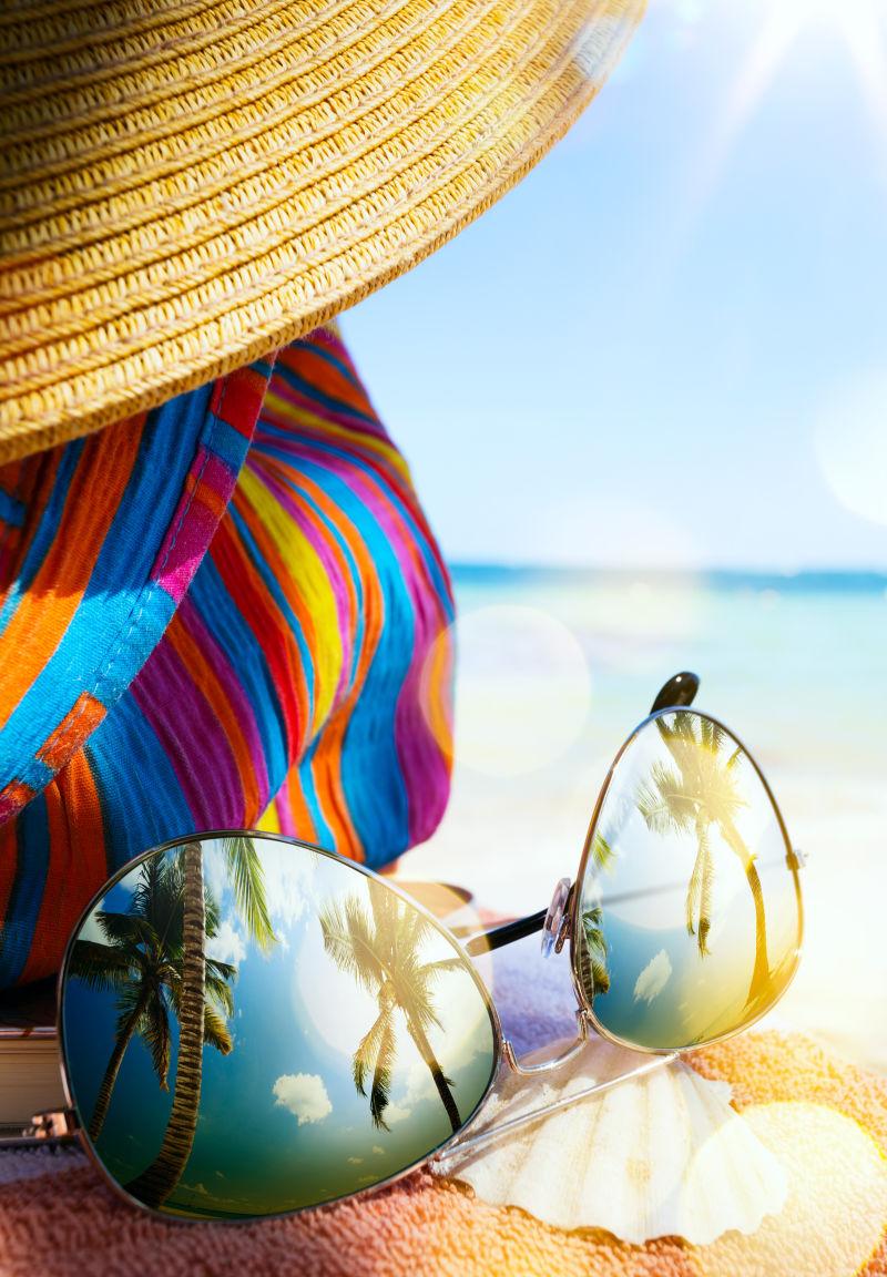 热带沙滩上的墨镜和草帽