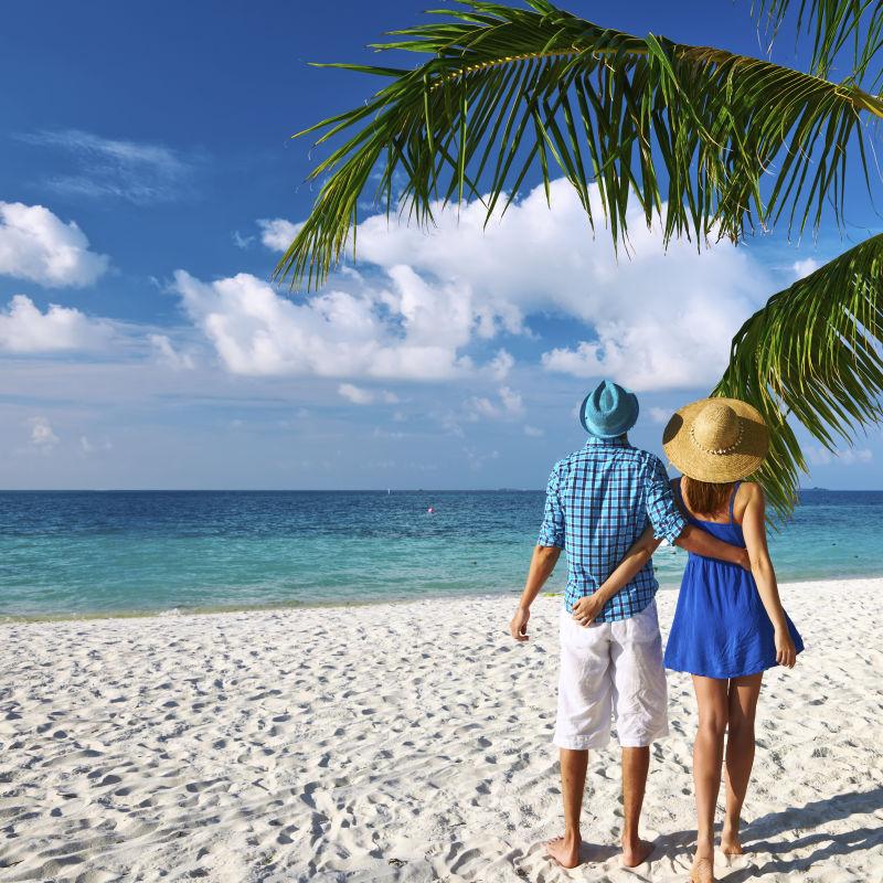 热带海滩度假的夫妇背景