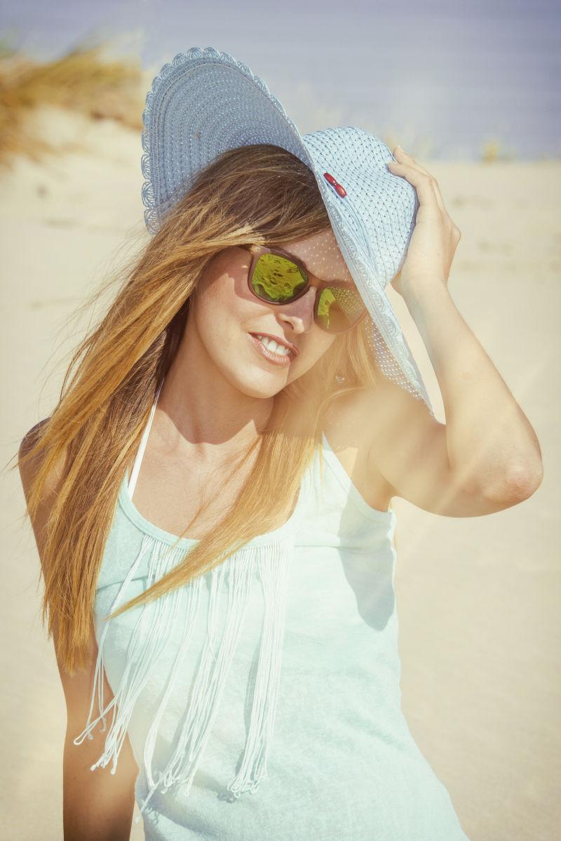 海滩上的带遮阳帽的年轻女子