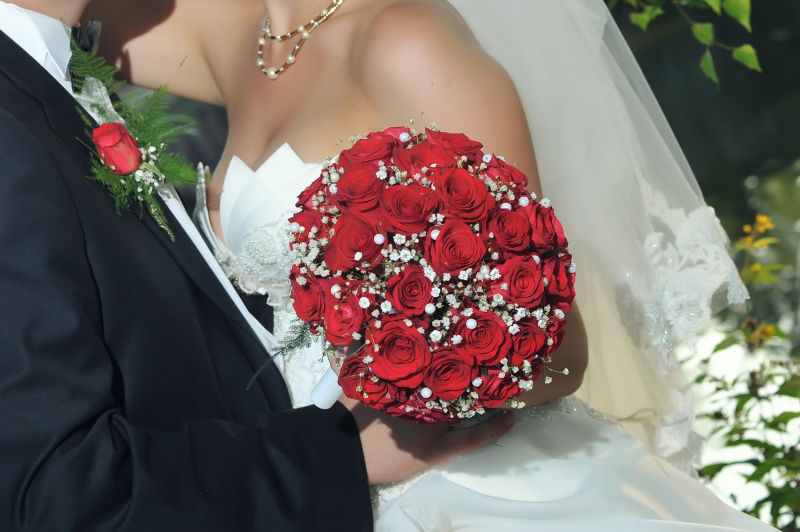 年轻漂亮的拿玫瑰花束的新娘