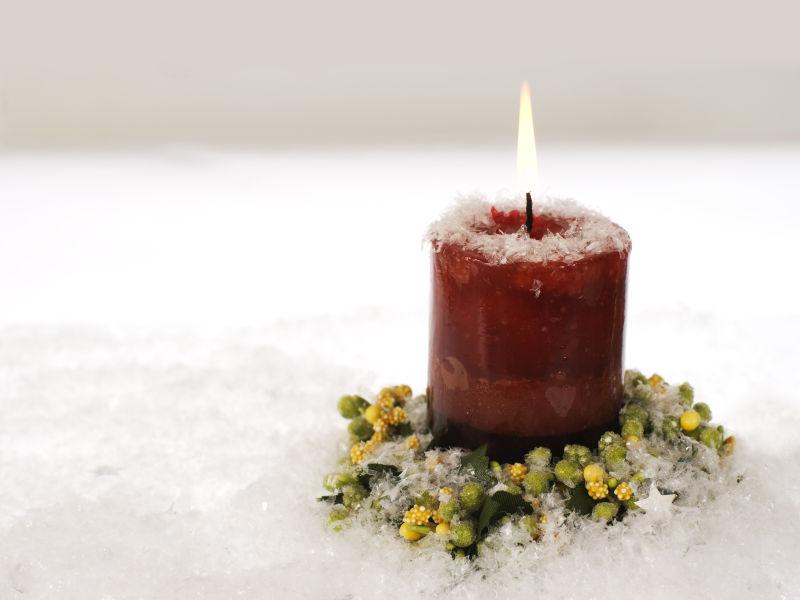 雪上的红色圣诞蜡烛