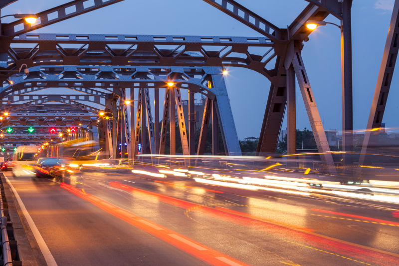 黎明-夜幕时分泰国曼谷的带有交通信号灯光的桥梁