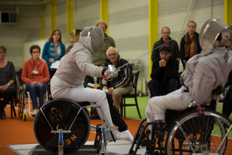 两名坐在轮椅上击剑的残疾运动员