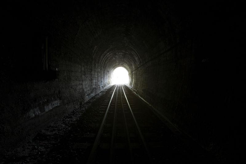 尽头有自然光的黑暗的隧道