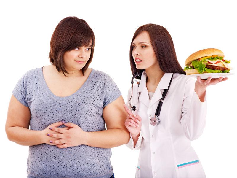 白色背景中的拿着汉堡的女医生和胖女人