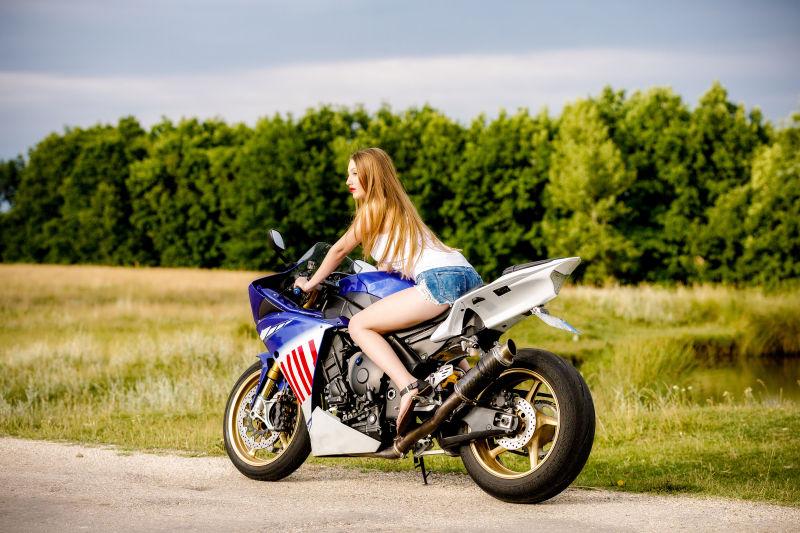 美丽的年轻女子骑摩托车