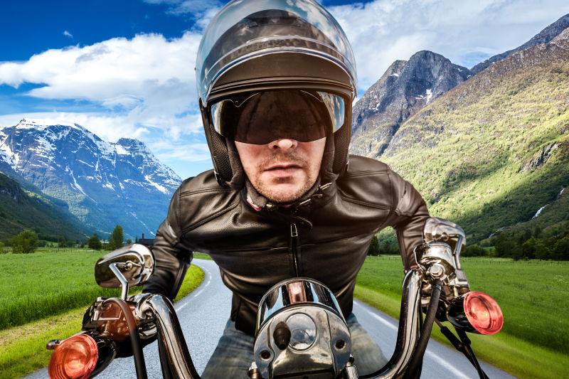 骑摩托车的男子戴头盔在路上飙车