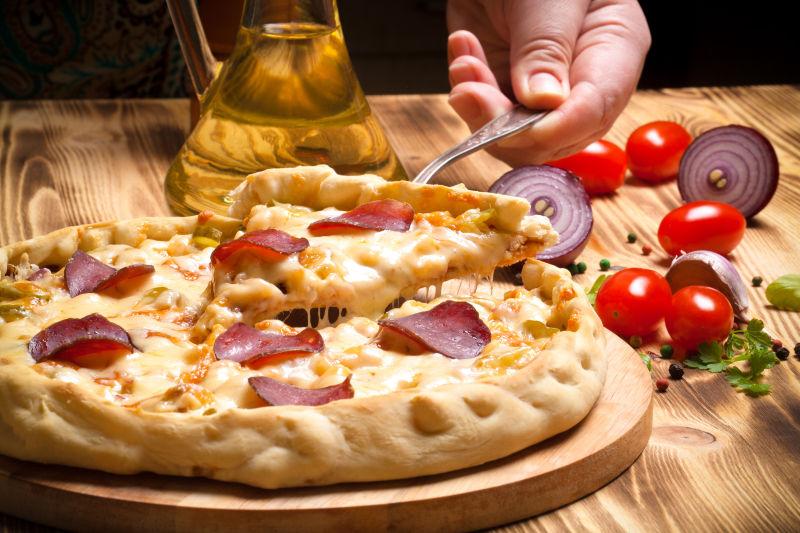 木桌上的奶酪香肠披萨