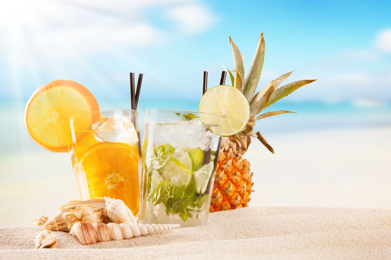 沙滩上的两杯水果饮料
