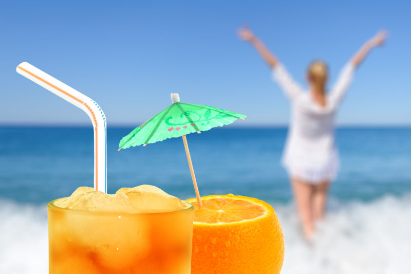 海滩背景下的橙子饮料