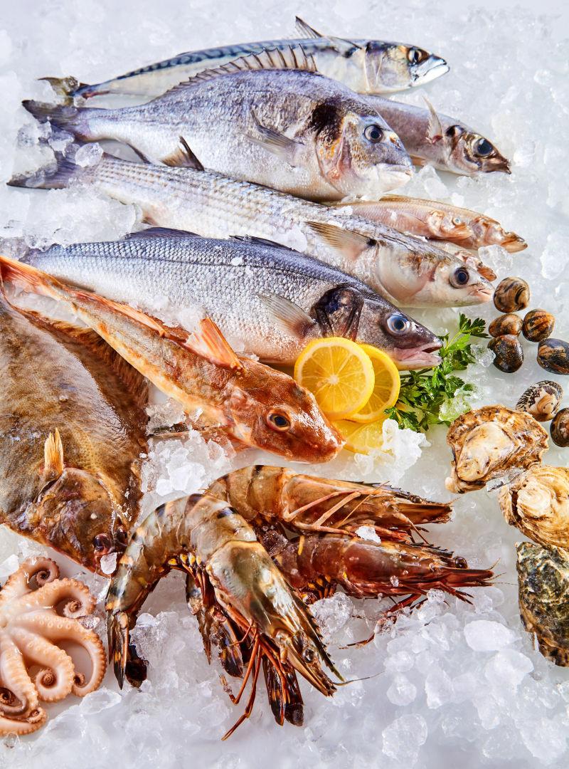 白色碎冰上散落的新鲜生鱼贝类和白海味等海鲜产品