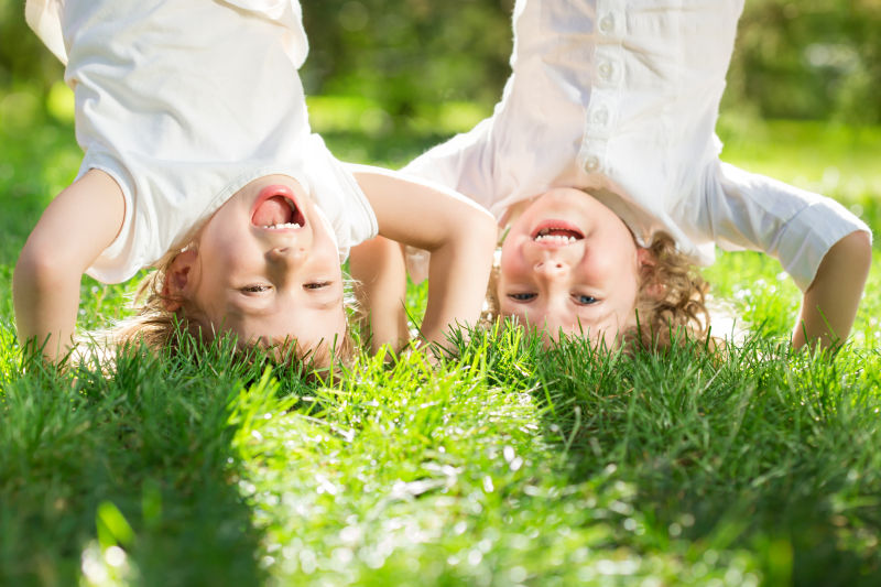 快乐的儿童在草地上倒立