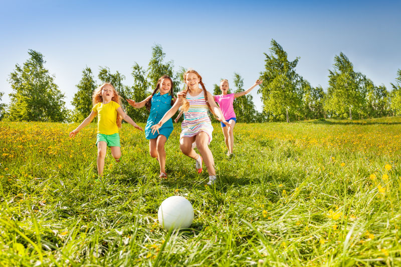 女孩子们在草地上踢足球