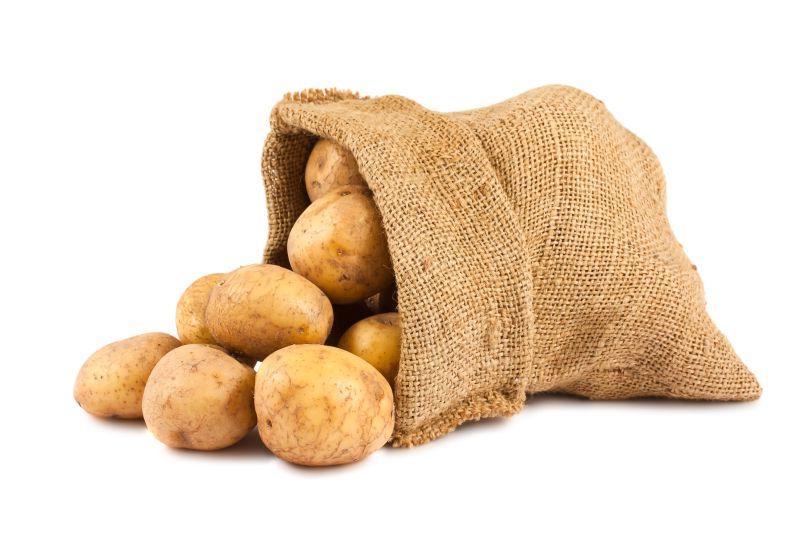 白色背景中的粗麻袋中的生土豆