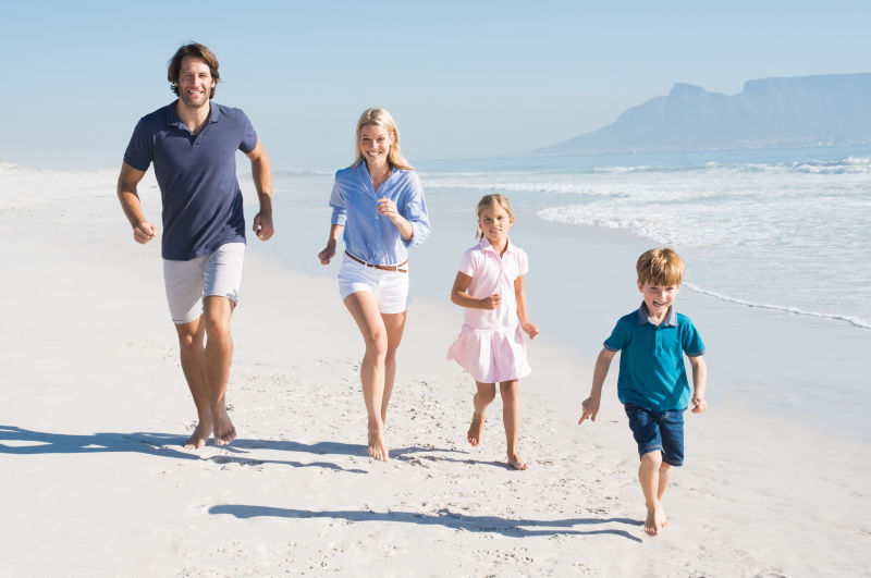 一家人在海滩上快乐的跑步