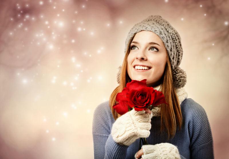 冬装美女拿着一朵美丽的玫瑰花