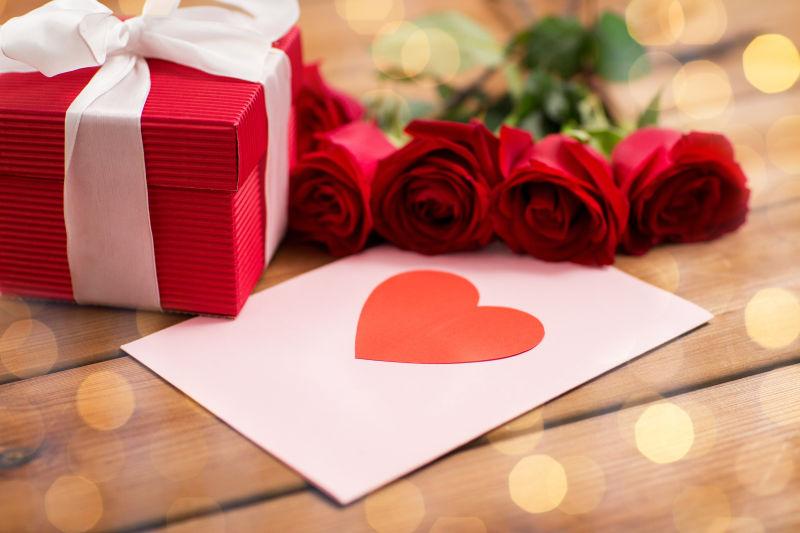 木板上的礼物盒和玫瑰花
