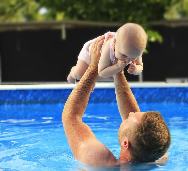 游泳池里父亲抱着自己婴儿