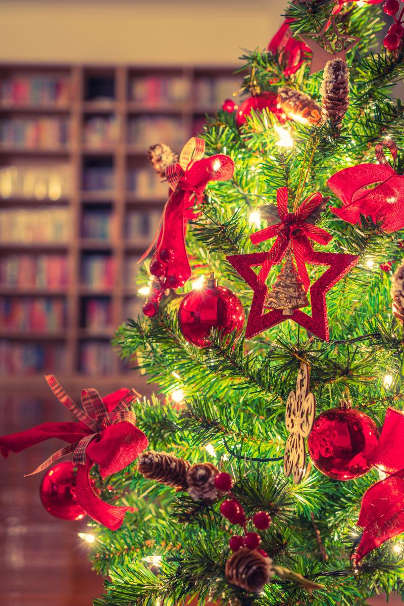 褐色书架背景下的圣诞树上的红色装饰品