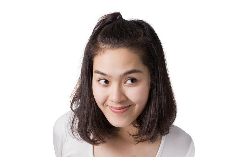 白色背景下微笑的年轻的亚洲女孩