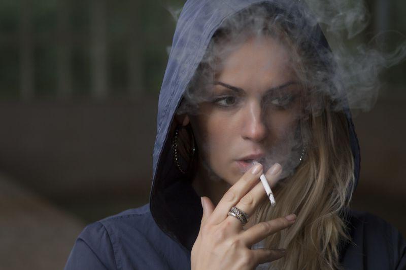 孤独的美女正在拿着香烟吸烟