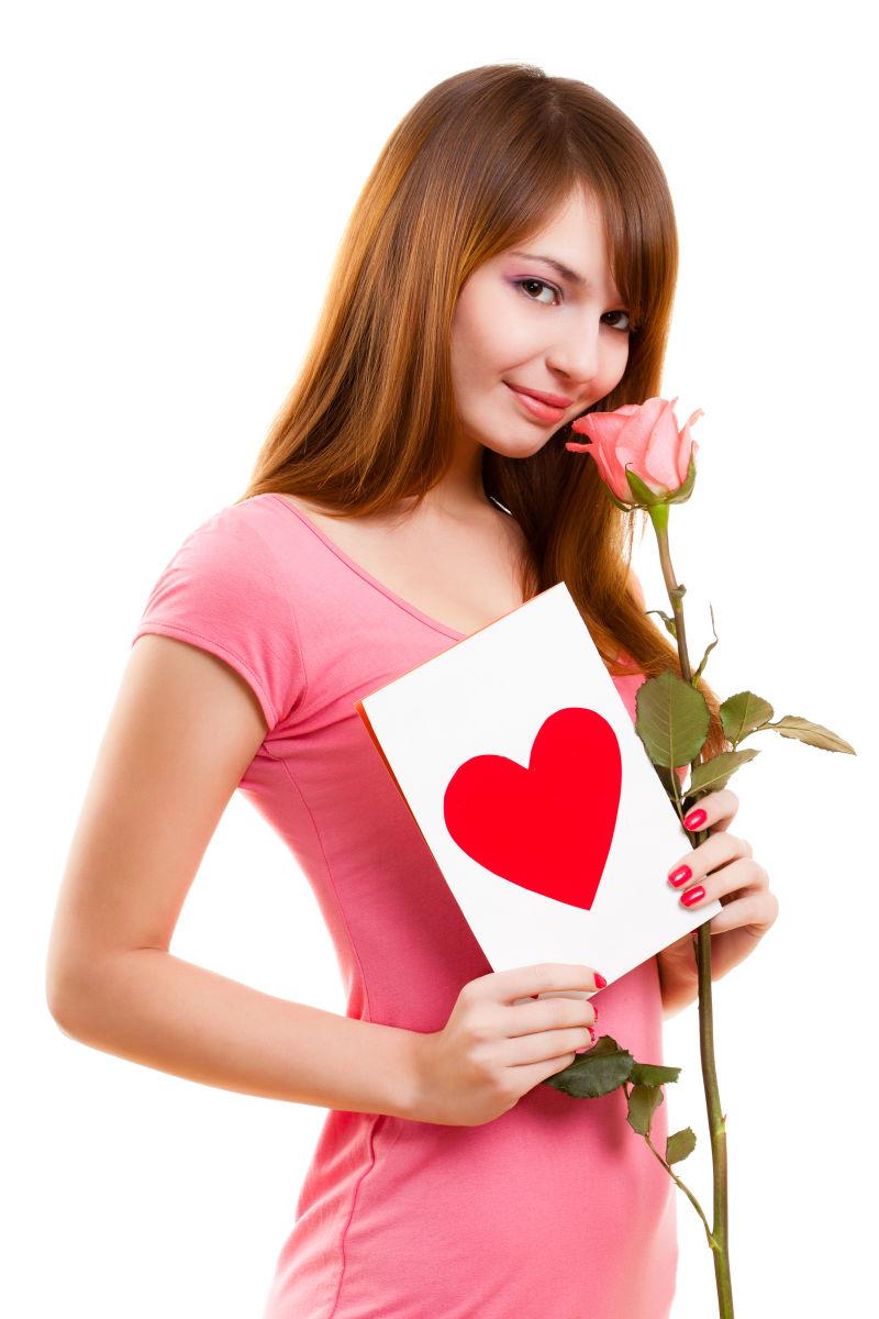 粉色衣服的美女拿着玫瑰花和情人节卡片