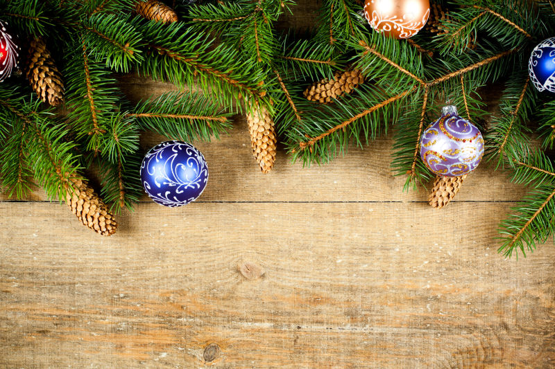 木板上的圣诞节树枝和圣诞铃铛
